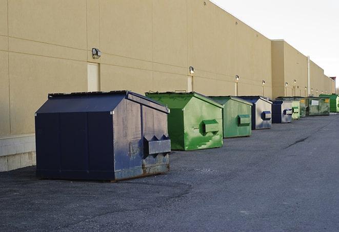 a row of yellow and blue dumpsters at a construction site in Baytown